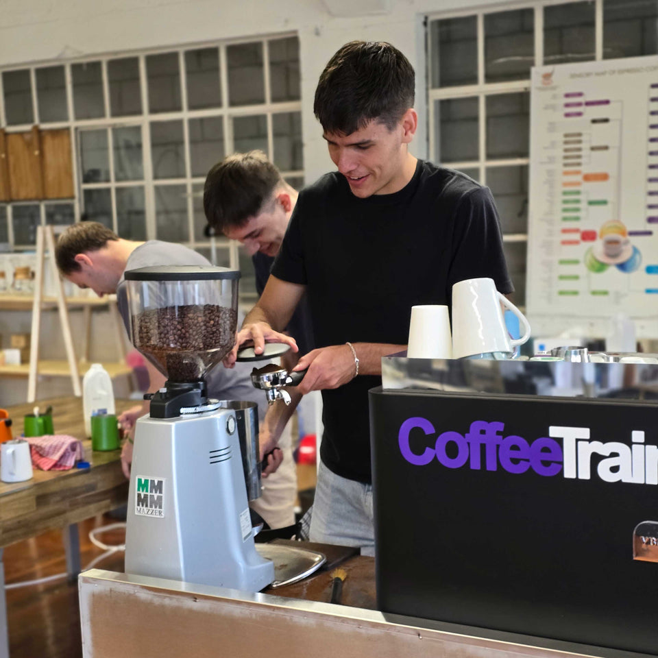 Person learning how to make cafe style on a commercial coffee machine